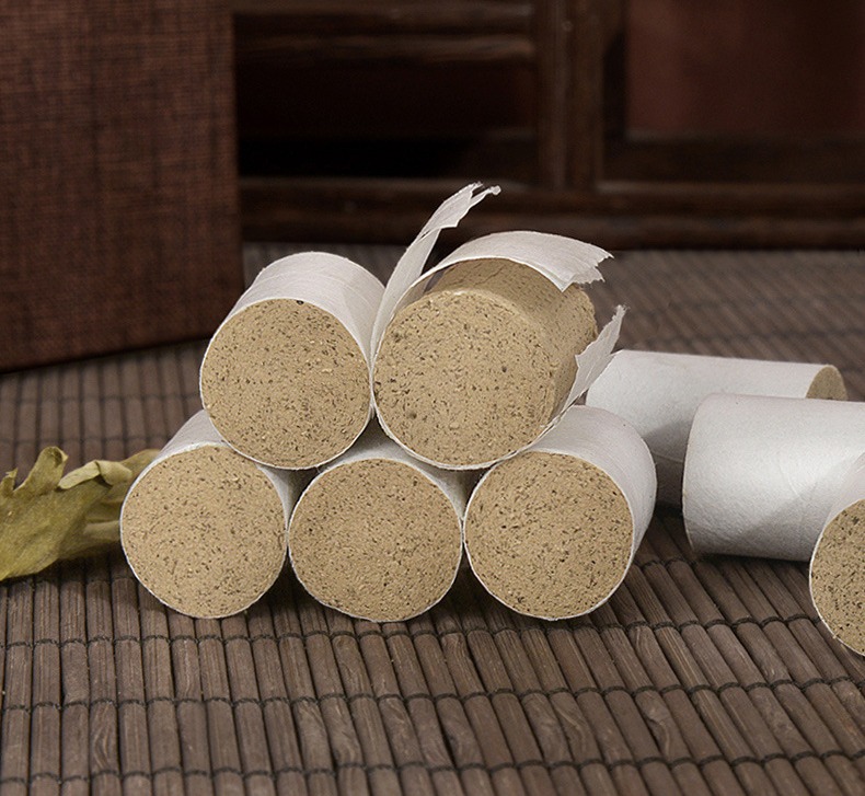White-paper-wrapped aged moxa cones, one with the wrap partly peeled (manufacturer detail photo).