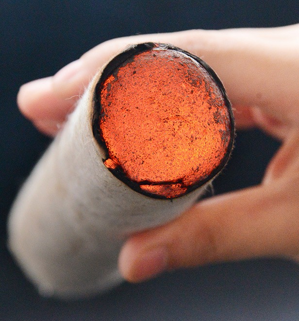 The lit end of a thick roll held in the hand (manufacturer detail photo).